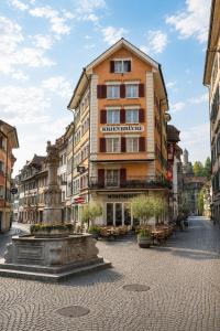a building on a street with a fountain in front of it at KB CityRooms Self-Check-In in Lucerne