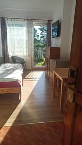 a bedroom with a bed and a table and a window at Hotelik Komandor in Władysławowo