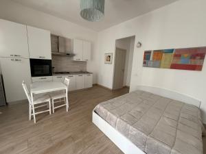 a bedroom with a bed and a table and a kitchen at B&B Casa Denittis in Peschici