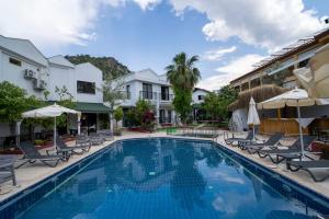 a pool at a hotel with chairs and umbrellas at Lagoonia Sun Hotel in Fethiye