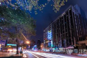 eine Stadtstraße in der Nacht mit Gebäuden und Straßenbeleuchtung in der Unterkunft 新仕飯店-New City Hotel in Taipeh