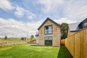 a brick house with a fence and a grass yard at Host & Stay - Thistle Cottage in Rochester