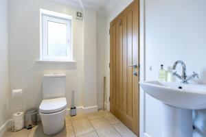 a bathroom with a toilet and a sink at The Dutch Barn in Stratton Audley +15 photos
