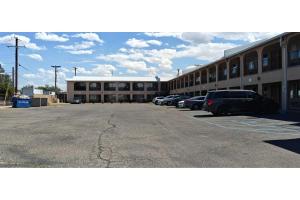 a parking lot with cars parked in front of a building at Albuquerque Inn Near Airport I 40 in Albuquerque