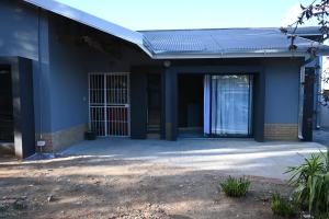 a blue building with a door and a patio at 49 Sannaspos in Bloemfontein