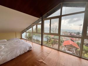 a bedroom with a bed and large glass windows at Hotel Galaxy View Tower in Nagarkot