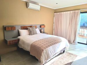 a bedroom with a large bed and a window at 49 Sannaspos in Bloemfontein