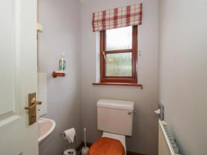 a bathroom with a toilet and a sink and a window at Byne Brook Cottage in Wistanstow +22 photos