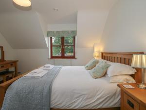 a bedroom with a bed with two towels on it at Byne Brook Cottage in Wistanstow