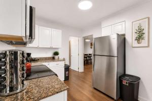 a kitchen with a stainless steel refrigerator and white cabinets at Center Field All Star Baseball Rentals in Oneonta