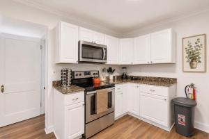 a kitchen with white cabinets and a stove top oven at Center Field All Star Baseball Rentals in Oneonta