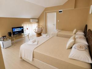 a bedroom with two beds and a flat screen tv at Hotel Kamelia in Varna City