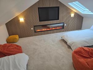 a bedroom with a fireplace and a tv on a wall at Dunderry Lodge Luxury Suites in Navan