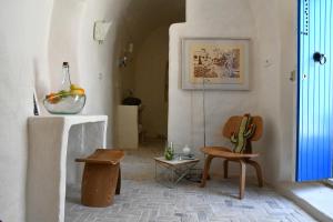 a living room with wooden chairs and a table at Dar Bibine in Erriadh