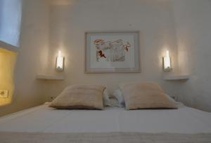 a bedroom with a white bed with two pillows at Dar Bibine in Erriadh