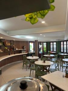 a restaurant with tables and chairs and a kitchen at Divi-Divi Praia Hotel in Natal