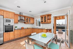 a kitchen with a table with a bowl of fruit on it at Villa Dori by Villa Select in Punta Prima