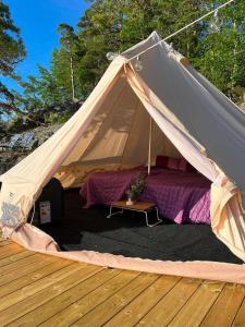 a tent with a bed on a wooden deck at Glamping on the waterfront in Hammarland