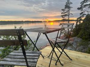 a table with a lamp and two chairs on a dock at Glamping on the waterfront in Hammarland +13 photos