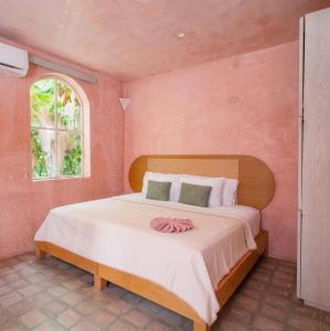 a bedroom with a large bed in a pink room at Casa Amate 61 - Mérida centro in Mérida +70 photos
