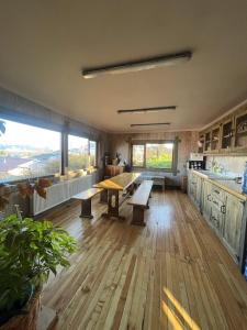 a large kitchen with wooden floors and tables and windows at Casa Oxidada in Puerto Natales
