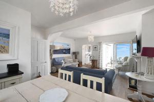 a living room with a blue couch and a table at Driftwood Cottage by Bloom Stays in Folkestone