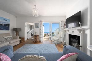 a living room with a blue couch and a fireplace at Driftwood Cottage by Bloom Stays in Folkestone