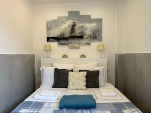 a bedroom with a bed with two paintings on the wall at Tourist House Bologna - Self check-in in Bologna