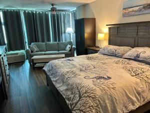 a bedroom with a bed and a couch in it at Oceanside Inn in Daytona Beach