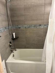 a white bath tub in a bathroom with a shower at Oceanside Inn in Daytona Beach +9 photos