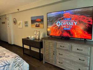 a bedroom with a flat screen tv on a dresser at Oceanside Inn in Daytona Beach