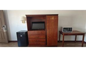 a large wooden entertainment center with a tv and a desk at Albuquerque Inn Near Airport I 40 in Albuquerque