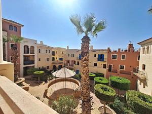 a palm tree and an umbrella in a courtyard at Harbour Lights IV in Villaricos
