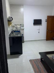 a kitchen with a sink and a tv on a wall at Voya Residence Dahab in Dahab
