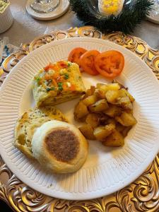 a plate of food with potatoes and bread and tomatoes at The Queen Anne Bed & Breakfast in Natchitoches