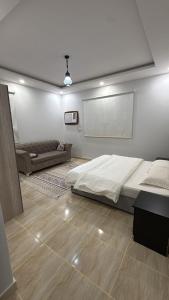 a bedroom with a bed and a couch in it at v2 غرفة وصالة in Al Wajh