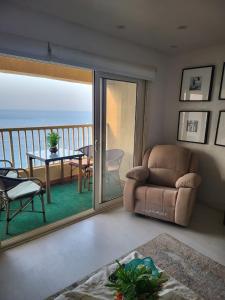 a living room with a couch and a table and a balcony at Nashwa m mohamed in Ain Sokhna