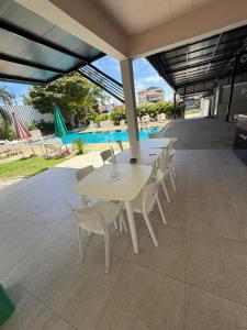 a table and chairs on a patio with a pool at Amaya Bloom Resort & Spa in Pattaya