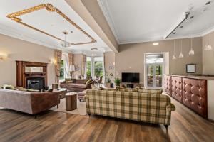 a living room with couches and a fireplace at Carlogie House in Carnoustie