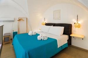a bedroom with a blue bed with towels on it at Miria B&B in Castrignano del Capo