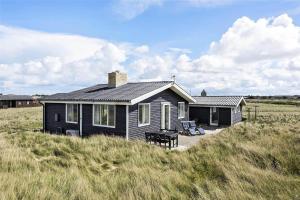 a black house in the middle of a field at LN76158-Hjorring-Bredningen-18 in Hjørring
