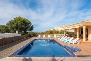 a swimming pool with lounge chairs and a house at Villa Dori by Villa Select in Punta Prima