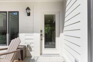 a white house with a white door and a chair at 774 Spinnaker Beach House in Seabrook Island +31 photos