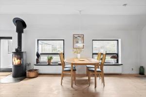 a dining room with a table and a wood stove at LN1913-Hjorring-Rubjergvej-11 in Hjørring +13 photos