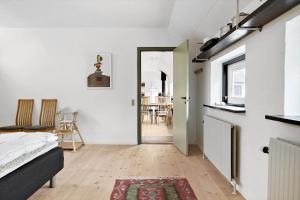 a bedroom with a bed and a kitchen with a table at LN1913-Hjorring-Rubjergvej-11 in Hjørring