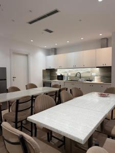 a room with tables and chairs and a kitchen at Bume's Hostel in Sarandë