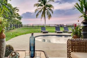 a bottle of wine sitting on a table next to a pool at Playa Potrero Beachfront Ocean Views, Pool & BBQ in Santa Cruz