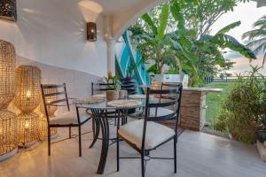 a table and chairs in a room with plants at Playa Potrero Beachfront Ocean Views, Pool & BBQ in Santa Cruz