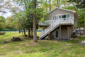 a small house with a deck and a tree at Sun Outdoors Cape May in Cape May