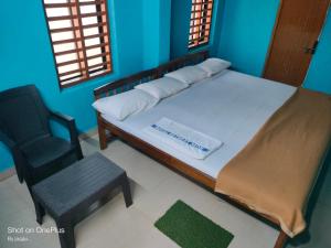 a bedroom with a bed with a chair and a window at Totadamane in murdeshwar in Māvalli